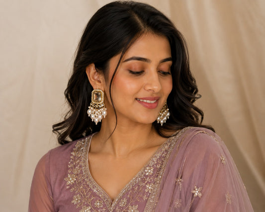 Model in a mauve embroidered kurta wearing gold emerald-cut crystal studs with a pearl cluster drop