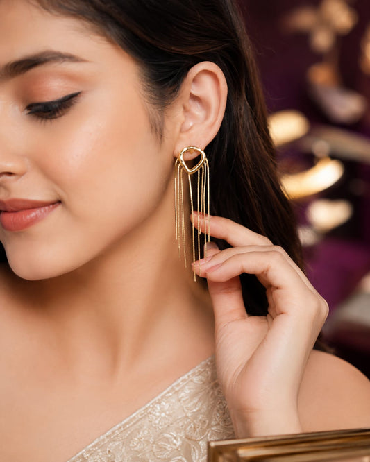 Model in an ivory embroidered saree wearing a gold-plated teardrop stud with a chain tassel fringe
