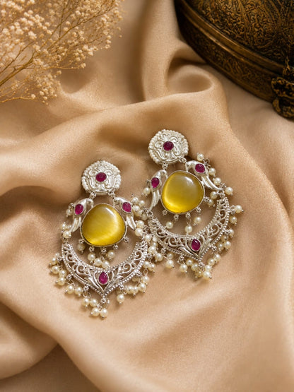 Oxidised silver chandbali earrings with a yellow cat's-eye stone, magenta accent stones and a pearl fringe
