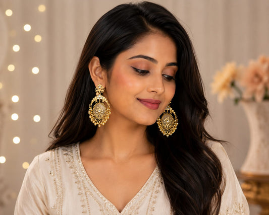 Model in an ivory embroidered kurta wearing gold-plated crescent chandbali earrings with a shell centre and bead fringe