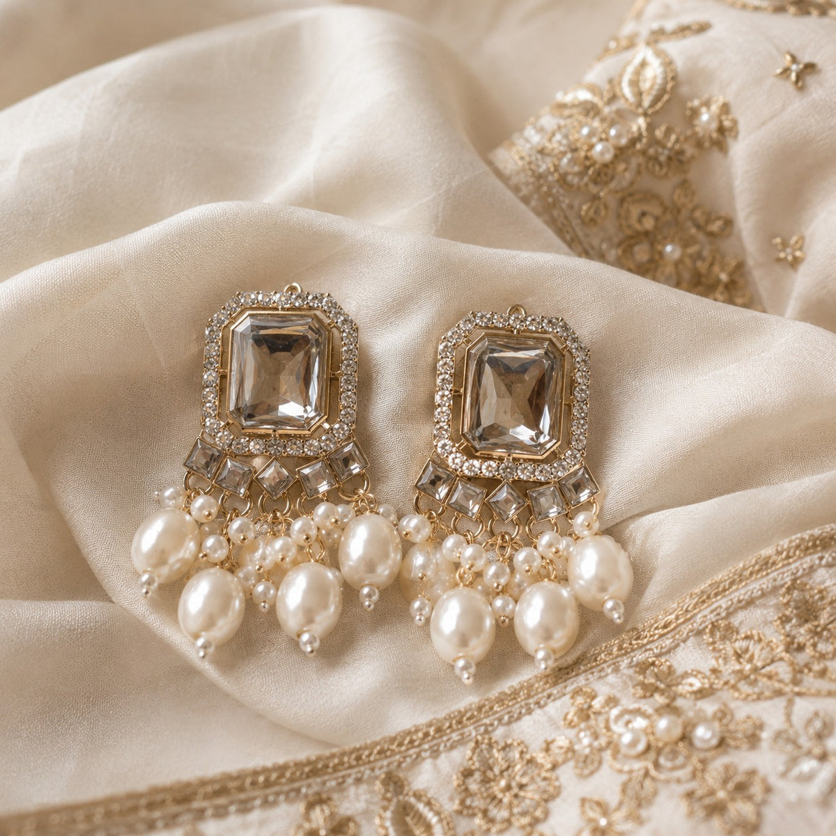 Gold-plated studs with a large emerald-cut crystal and a cluster of round and oval faux pearls on ivory silk