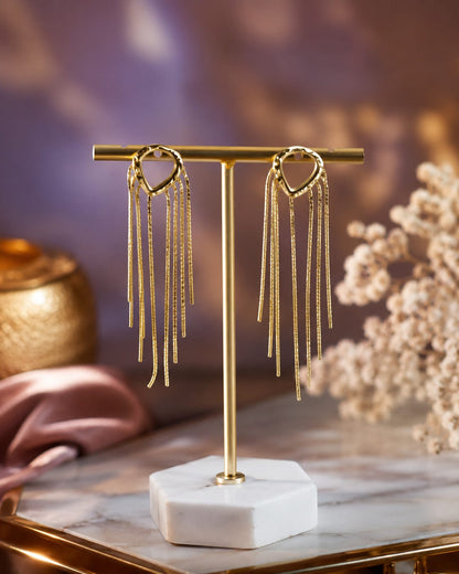 Gold-plated teardrop stud earrings with a fringe of textured chain tassels on a brass display stand