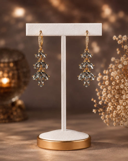 Gold-plated crystal leaf drop earrings with three tiers of grey marquise stones on a pave huggie hoop