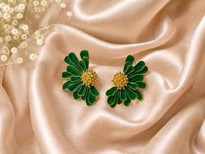 Green enamel floral stud earrings with textured gold centres on champagne satin