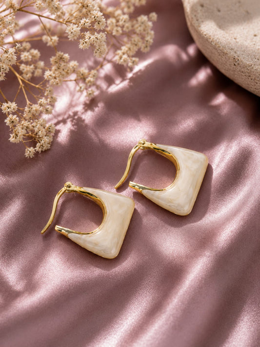 Ivory marbled resin square hoop earrings with a gold-plated frame on pink satin
