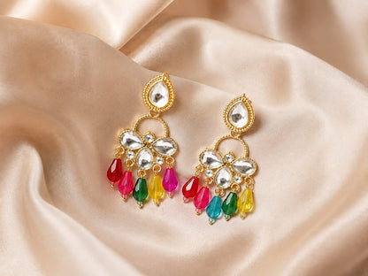 Gold-plated kundan chandelier earrings with red, pink, green and yellow bead drops on champagne satin