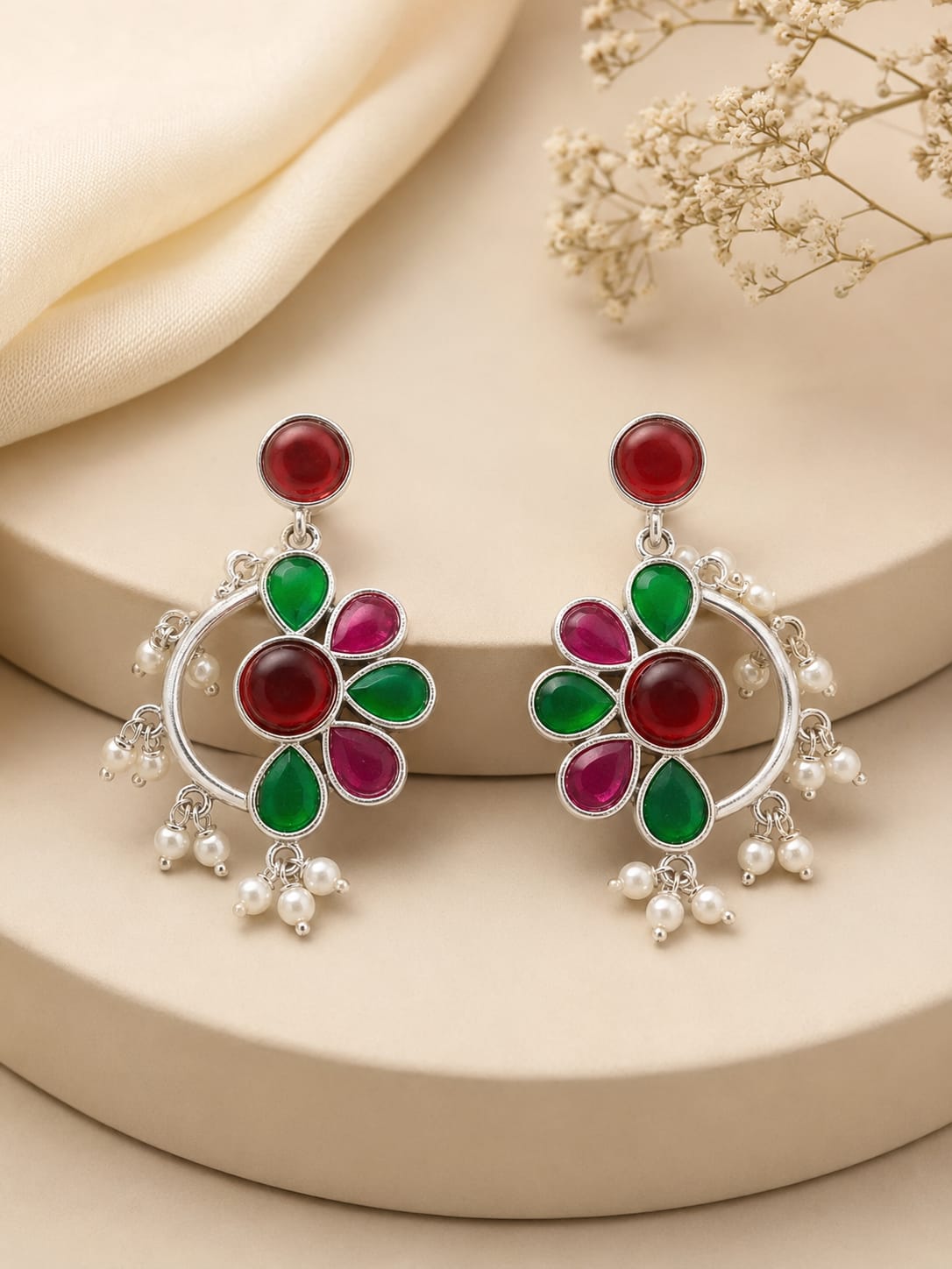 Pair of silver crescent chandbali earrings with ruby and emerald petals and white pearl drops