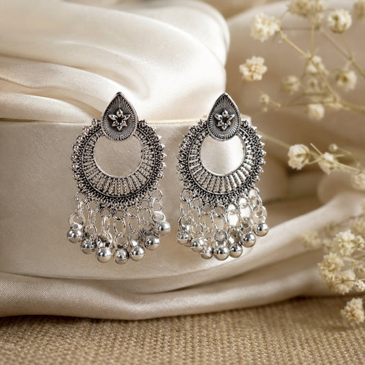 Oxidised silver chand bali earrings with rope-worked open frames and a fringe of small silver bells on ivory satin