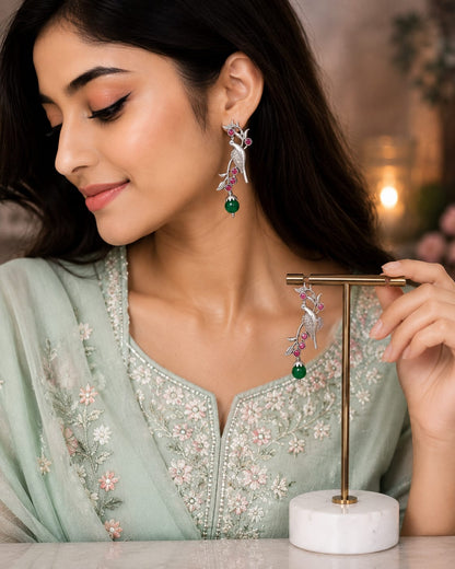 Model in a mint green embroidered kurta wearing oxidised parrot earrings with ruby stones and a green drop