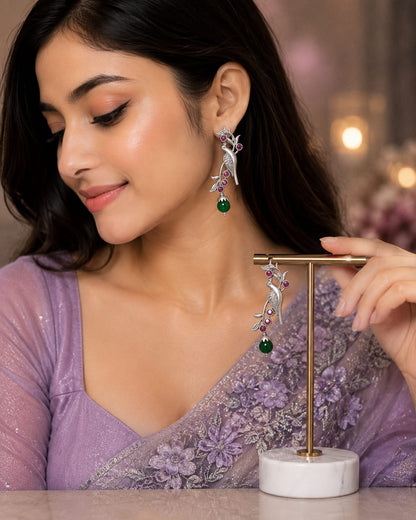 Model in a lilac sequinned saree wearing oxidised silver parrot earrings with ruby stones and a green bead drop