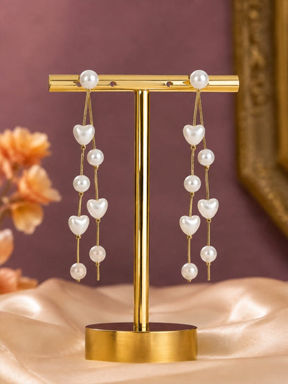 Long gold chain earrings with pearl hearts and round pearls on a gold T-stand