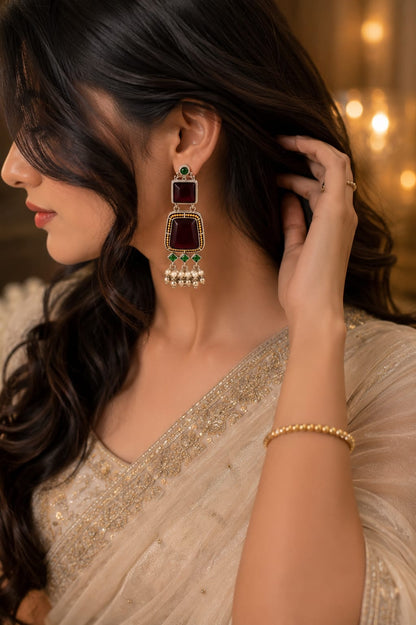 Model in an ivory sequinned saree wearing maroon and green oxidised stone drop earrings